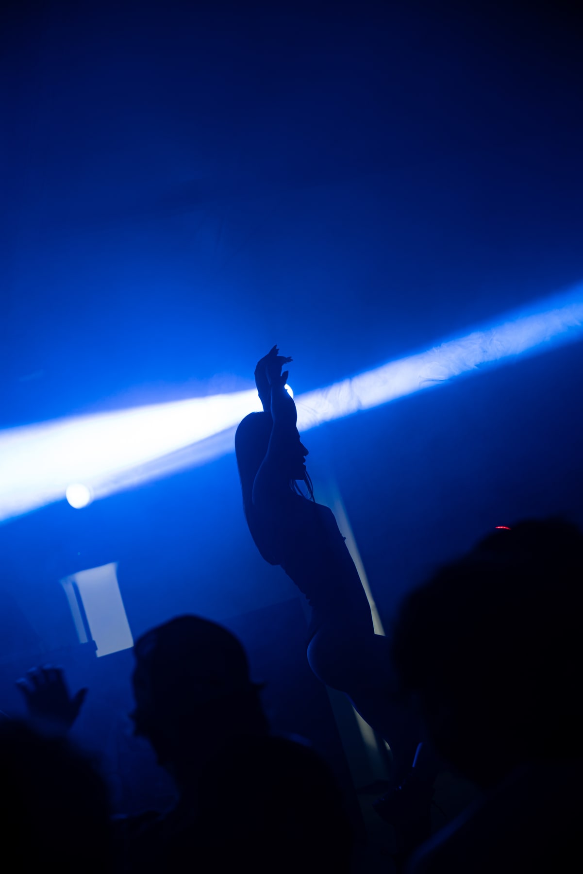Un performer in silhouette sul palco illuminato di blu.